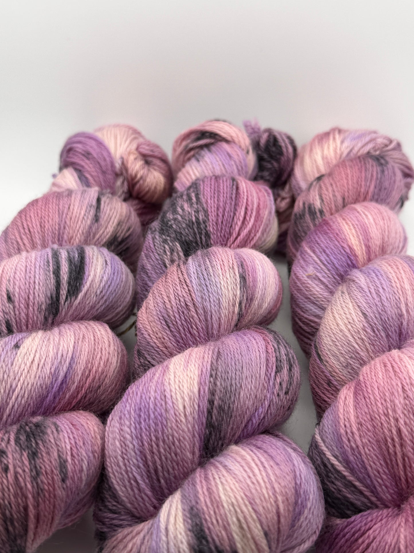 Hand dyed yarn in the UK dyed in small batches. Lilac Skies, purple violet and heather tones.
