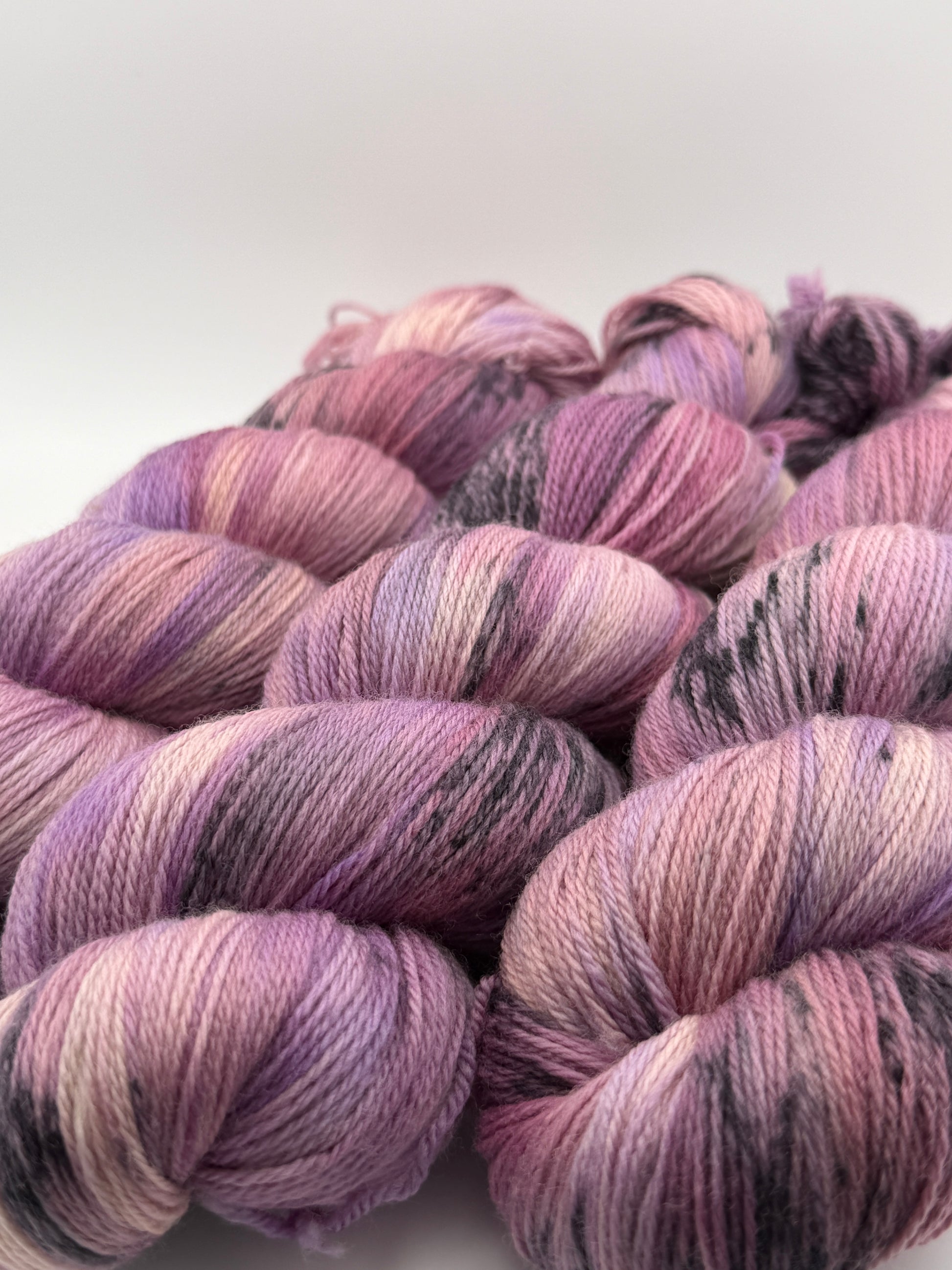 Hand dyed yarn in the UK dyed in small batches. Lilac Skies, purple violet and heather tones.