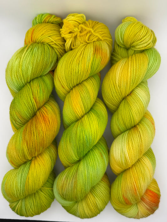 Hand dyed yarn available in 4ply sock, aran, DK in Sour Candy colourway – green and yellow tones with orange speckled yarn
