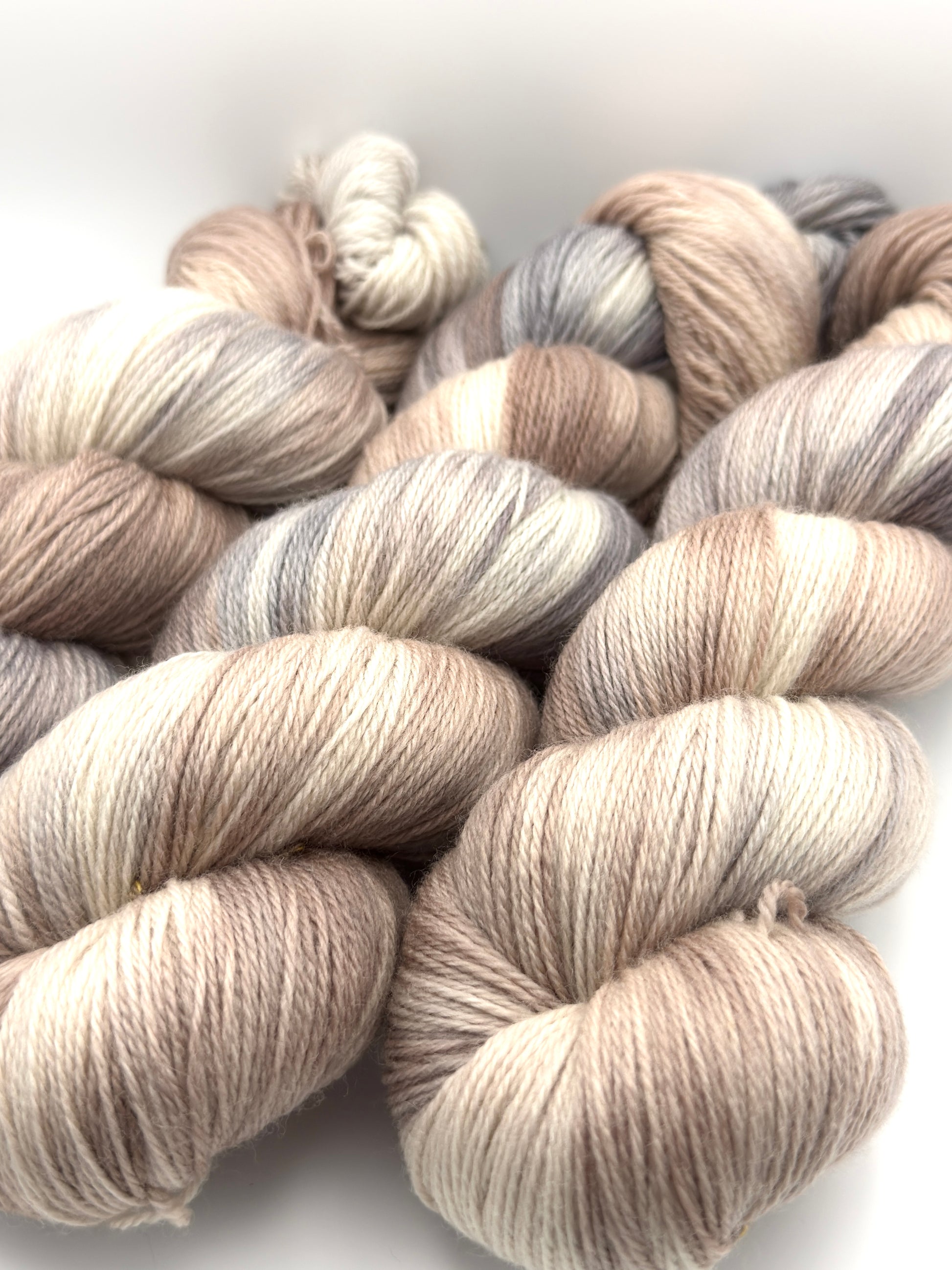 Hand dyed yarn UK available in 4ply sock, aran, DK in Pebble Shore colourway – neutral and grey tones.