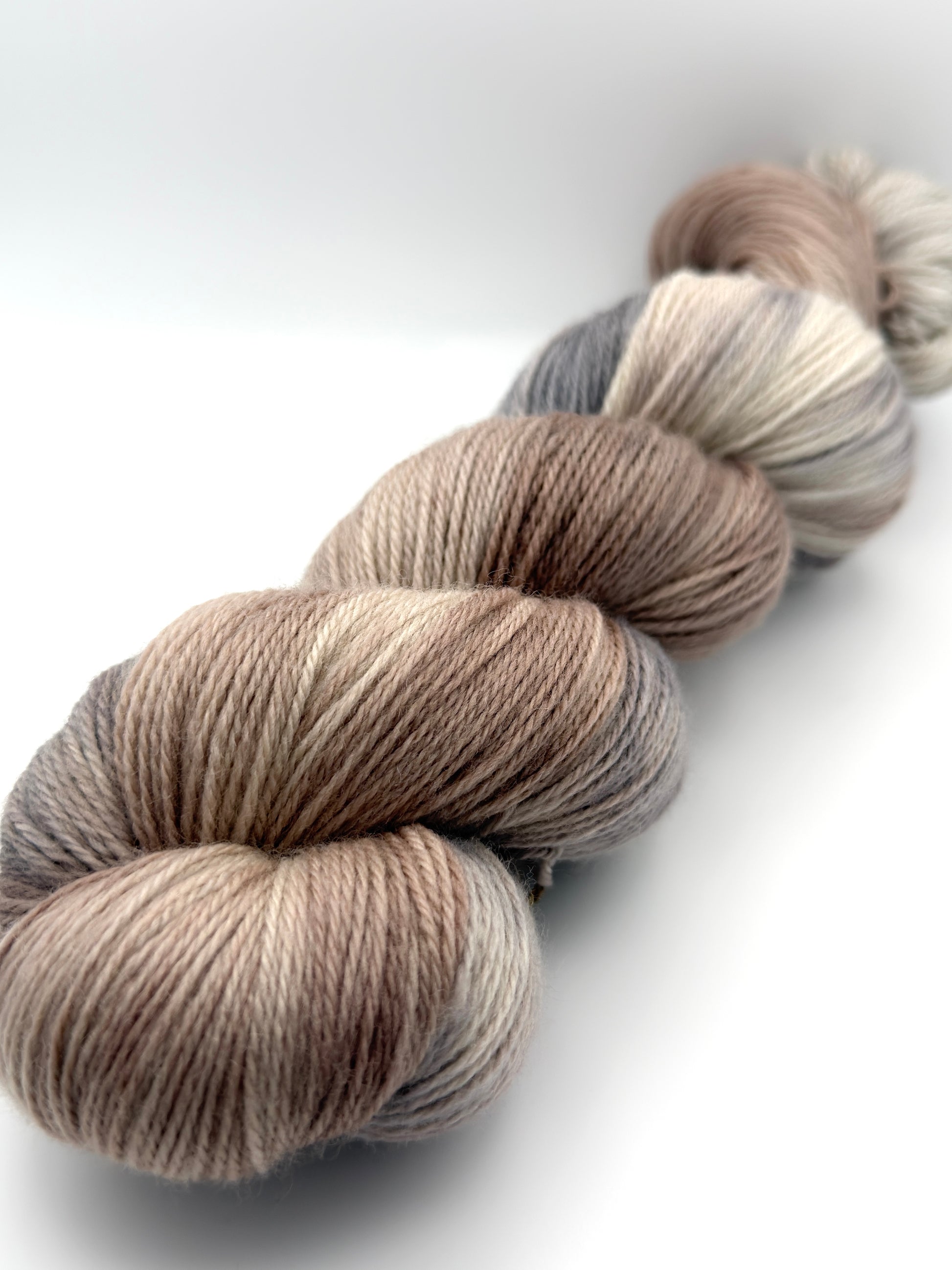 Hand dyed yarn UK available in 4ply sock, aran, DK in Pebble Shore colourway – neutral and grey tones.